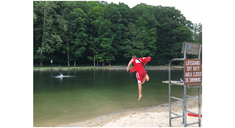 a life guard jumping out of his chair to practice rescuing a swimmer at the Green River.png